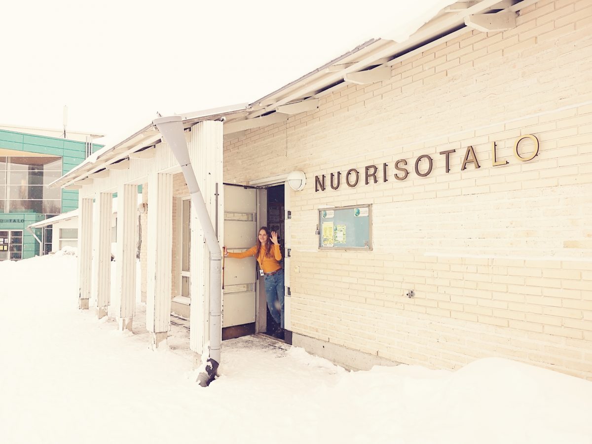 Ohjaaja vilkuttaa Oulunsalon nuorisotalon ulko-ovelta