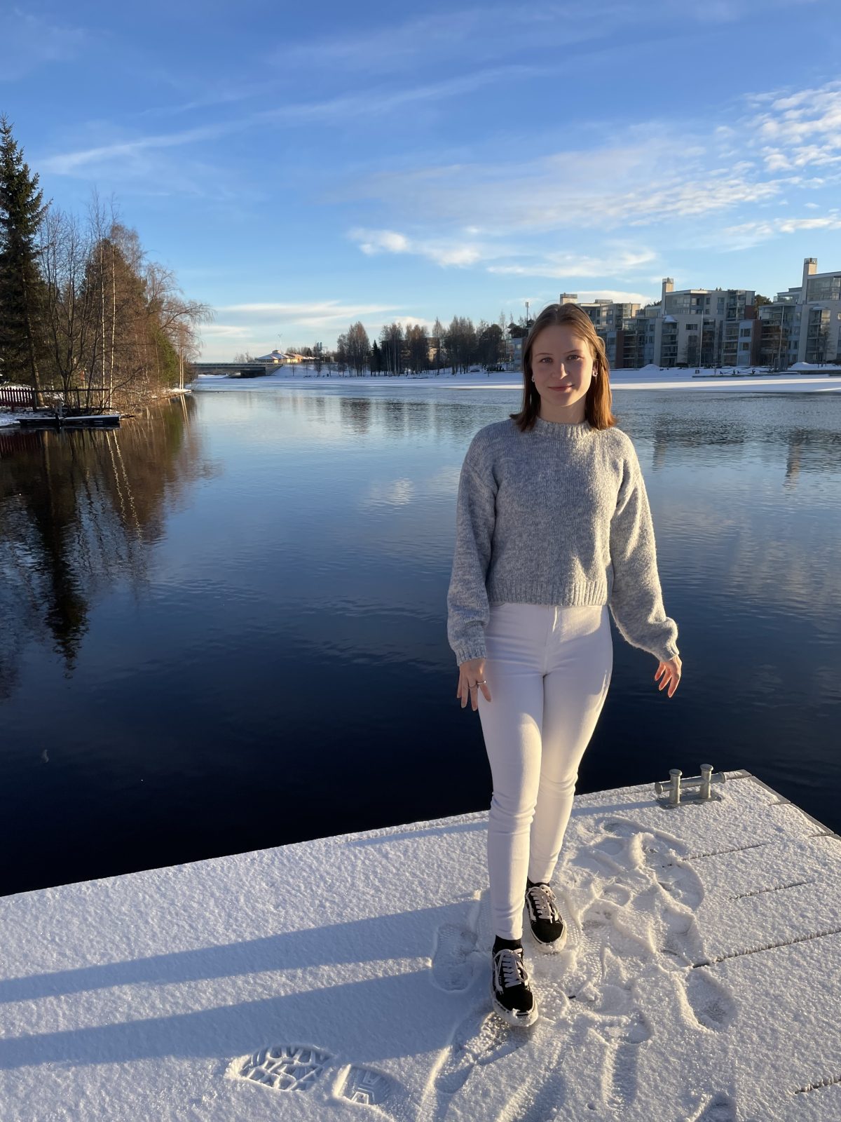 Sosionomiopiskelija Milla on opintoihin liittyvässä harjoittelussa Myllyojan nuorisotilalla. Kuvassa Milla on Oulujoen rannassa laiturilla talvella.