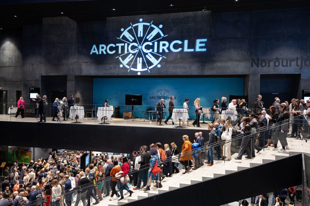 Paljon ihmisiä portaissa Arctic Circle logon alla.